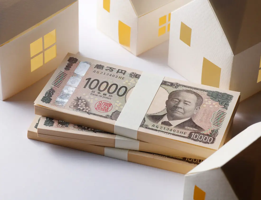 住宅の模型と一万円札の束